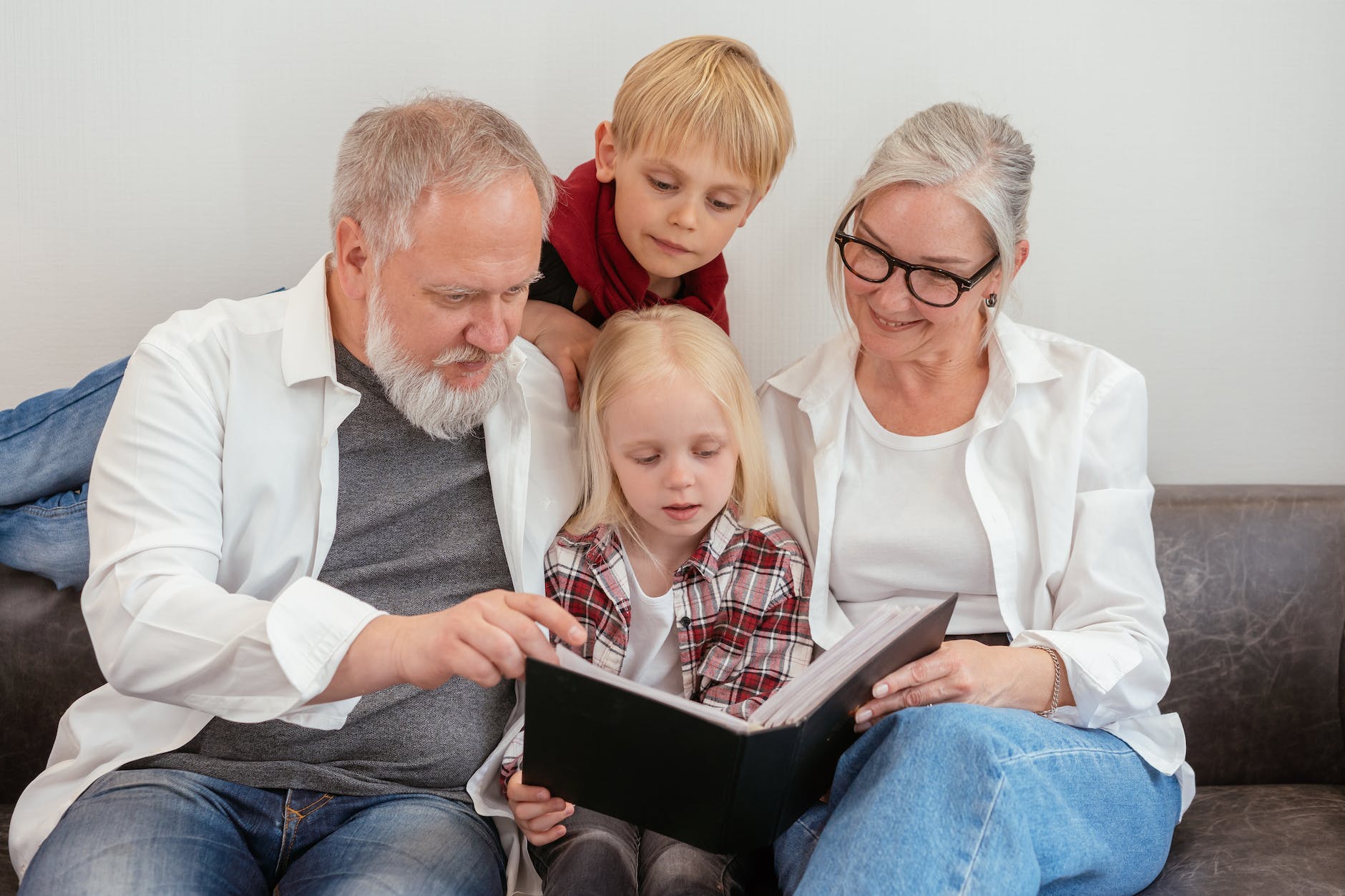 a family looking at a album / Los Abuelos y Su Importancia en la Crianza De Mellizos